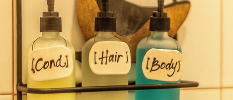A bathroom shelf with three bottles labeled 'Cond.', 'Hair', and 'Body'.