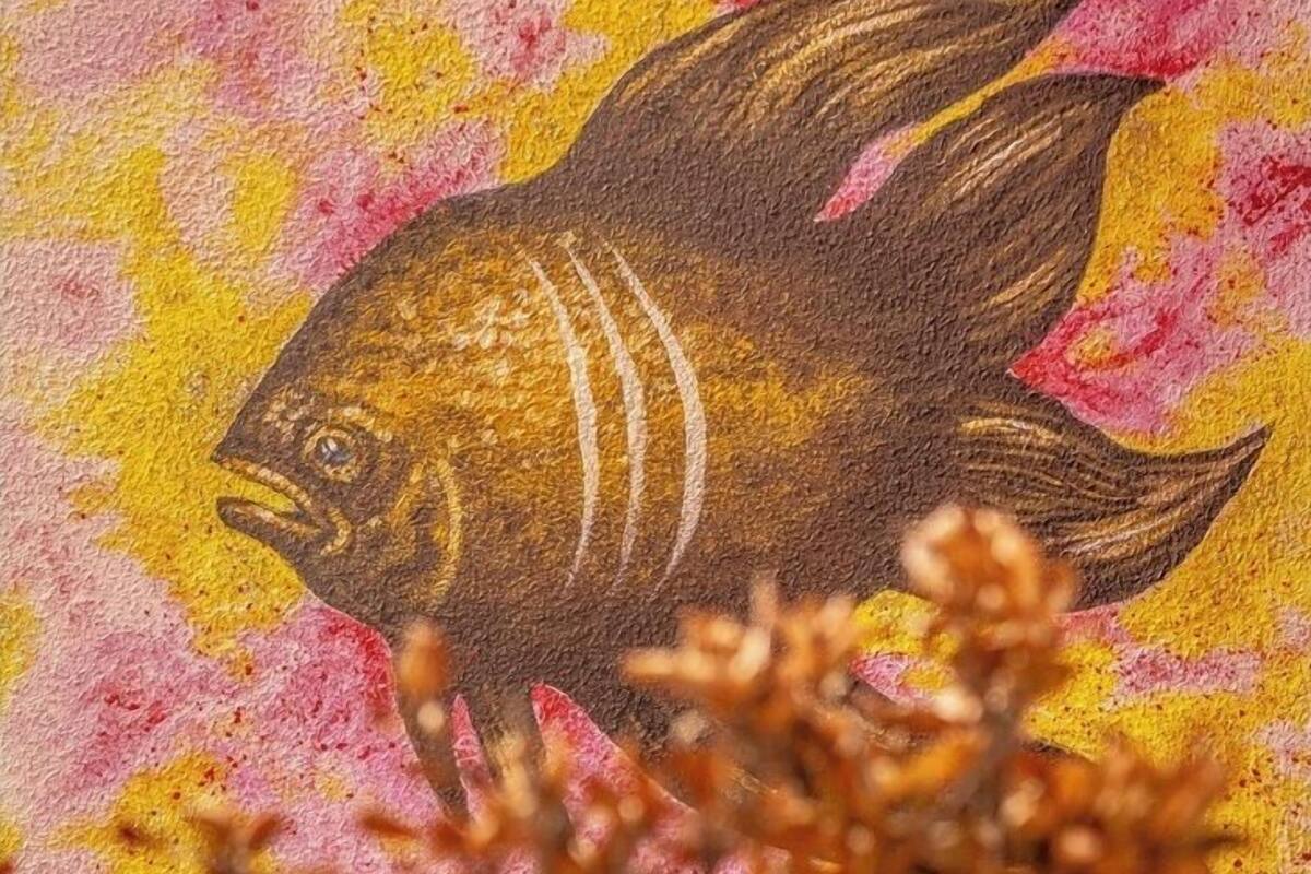 Ein Fischgemälde an einer strukturierten Wand.