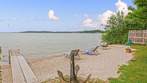 Une plage avec une terrasse en bois, des chaises longues et une décoration rustique en forme d’ancre.