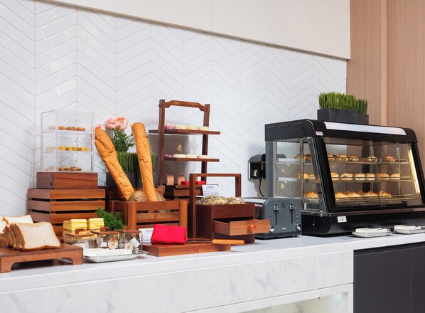 A bakery counter with bread, pastries, and a coffee machine. - Holiday Inn Express Beijing Zhongguancun Tech Park by IHG (Beijing)