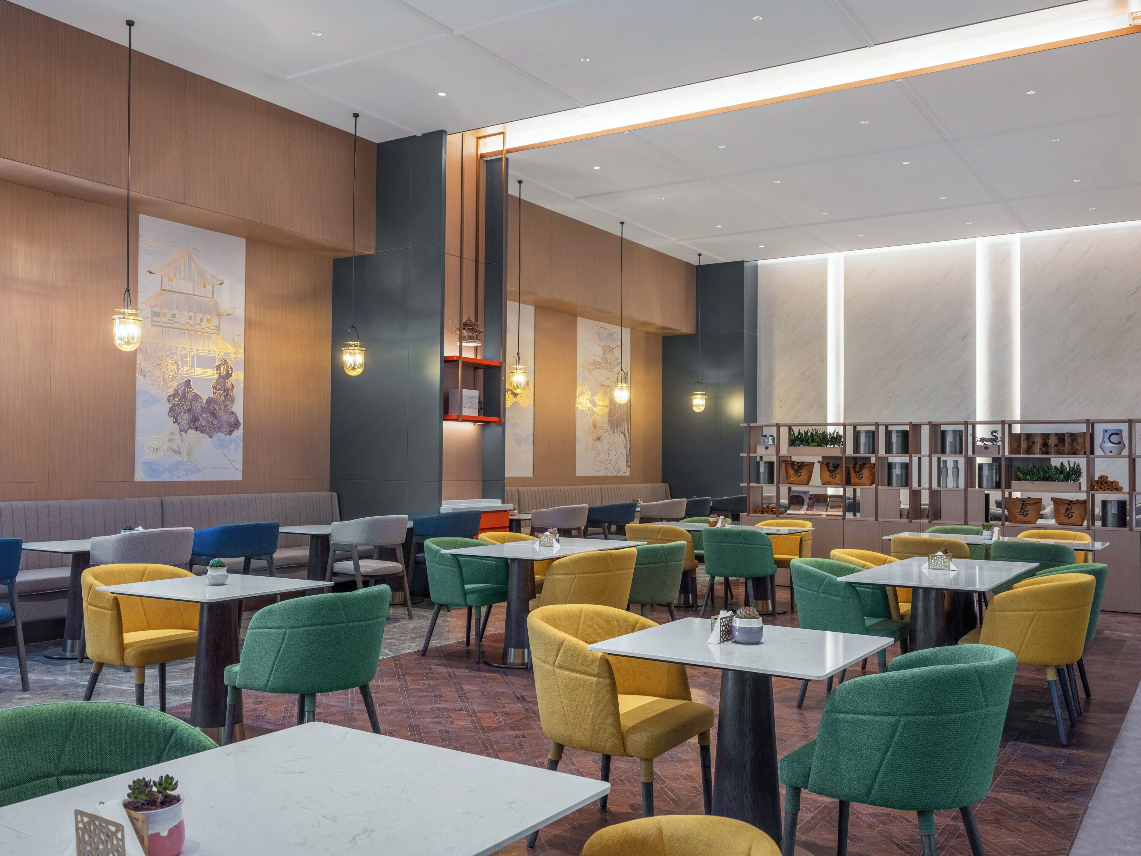 Un interior de restaurante moderno con cabinas, mesas y sillas coloridas.
