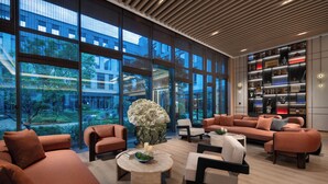 A modern interior with large windows, a central seating area, and a bookshelf. - Holiday Inn Express Beijing Zhongguancun Tech Park by IHG (Beijing)