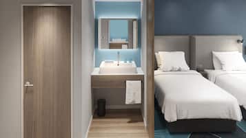 A modern hotel room with a wooden door, a bathroom with a sink and mirror, and two beds with white bedding.