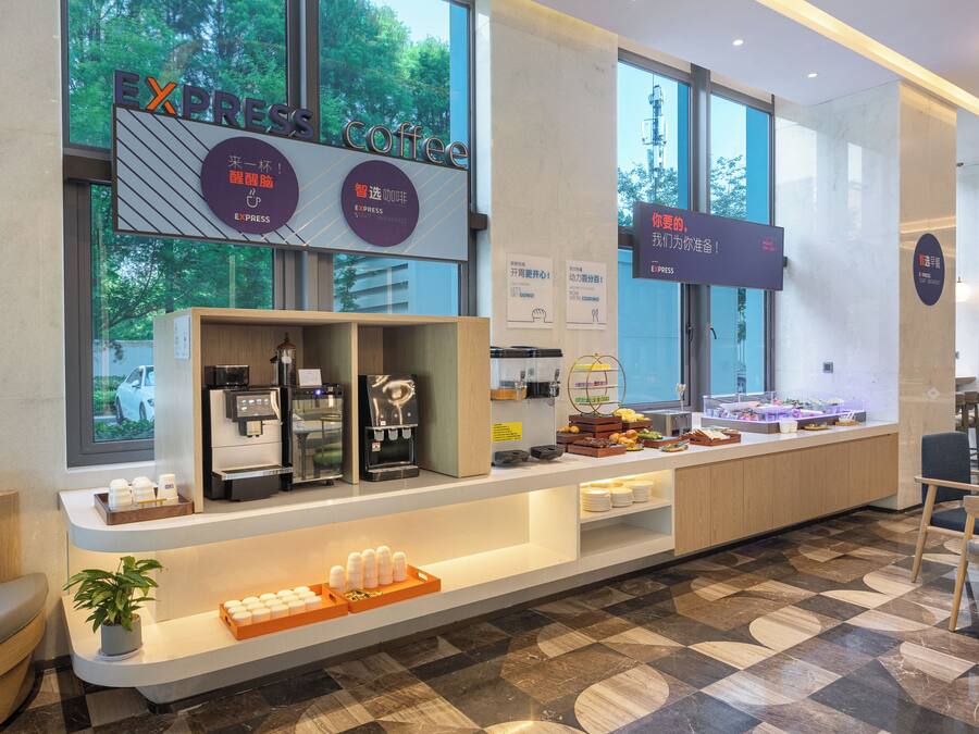 A modern coffee shop with a clean, minimalist design, featuring a coffee bar, seating area, and large windows offering a view of the outdoors.