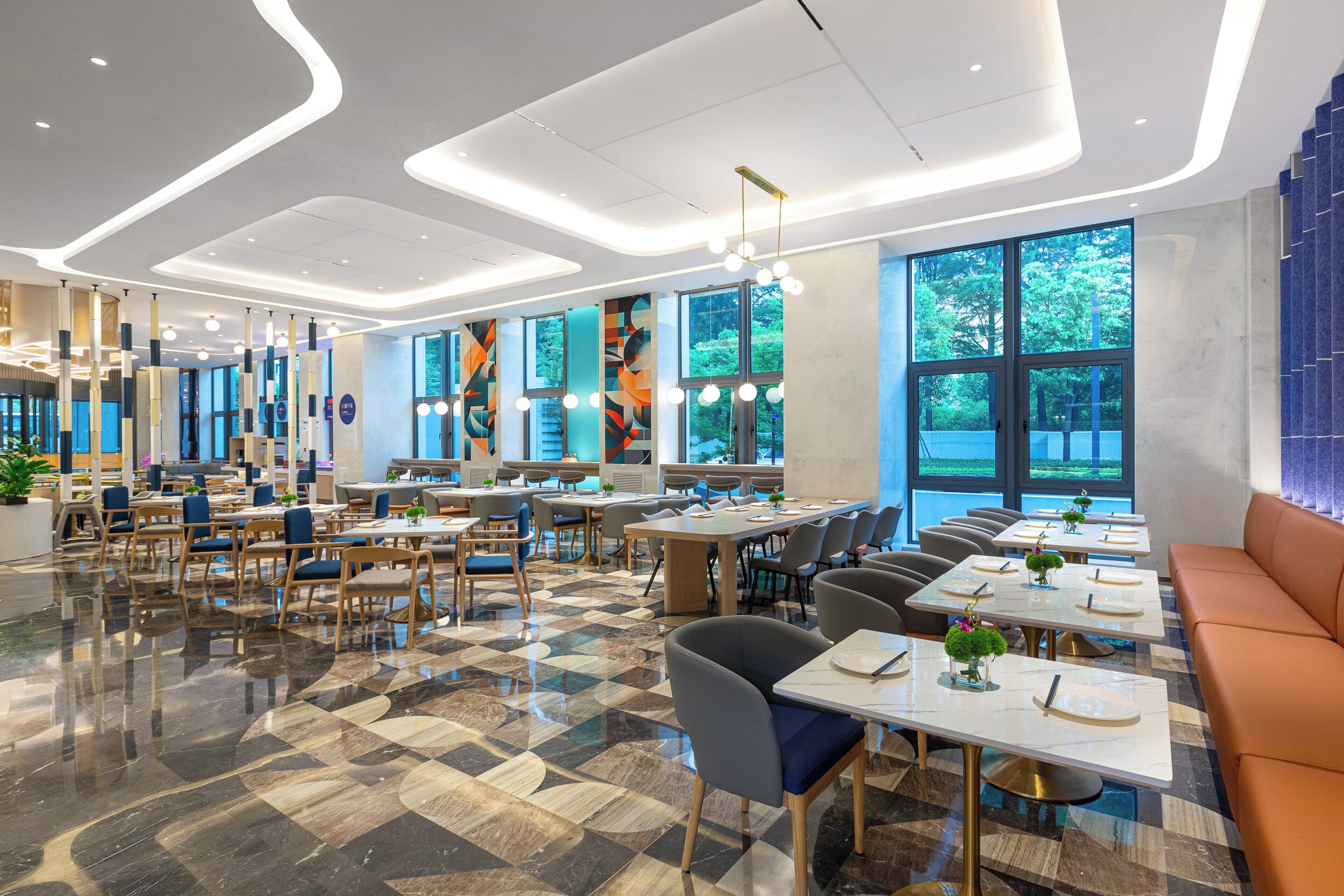 Um restaurante moderno com piso xadrez, várias mesas e cadeiras.