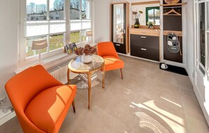 Relax in this stylish room with a view, featuring a comfortable seating area and large windows.