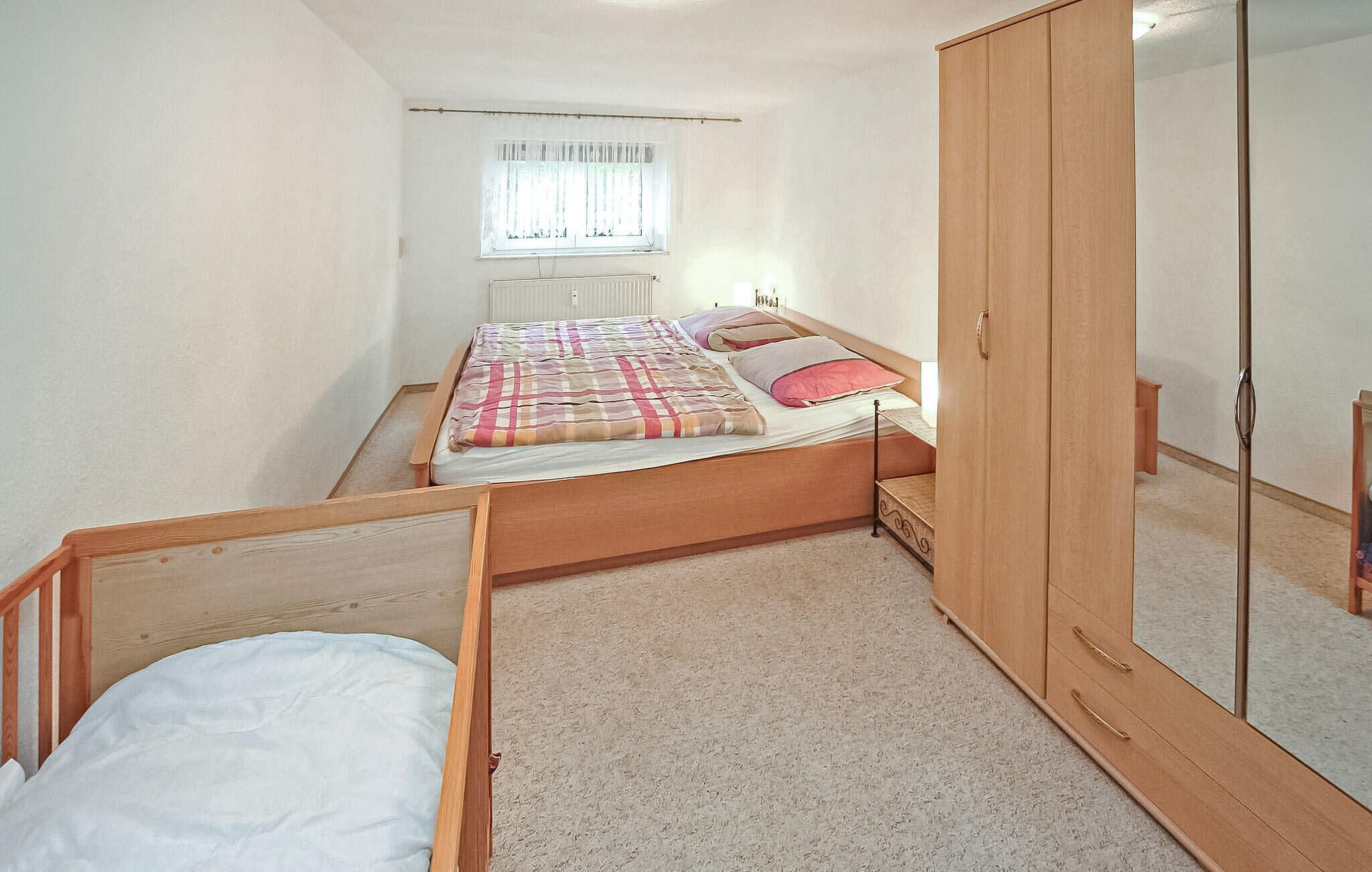 Une chambre à coucher avec un lit, une armoire et une fenêtre.