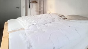 A bedroom with two beds, a wardrobe, and a hanging rack. - Ferienwohnung Schwarzenberg (Schwarzenberg)
