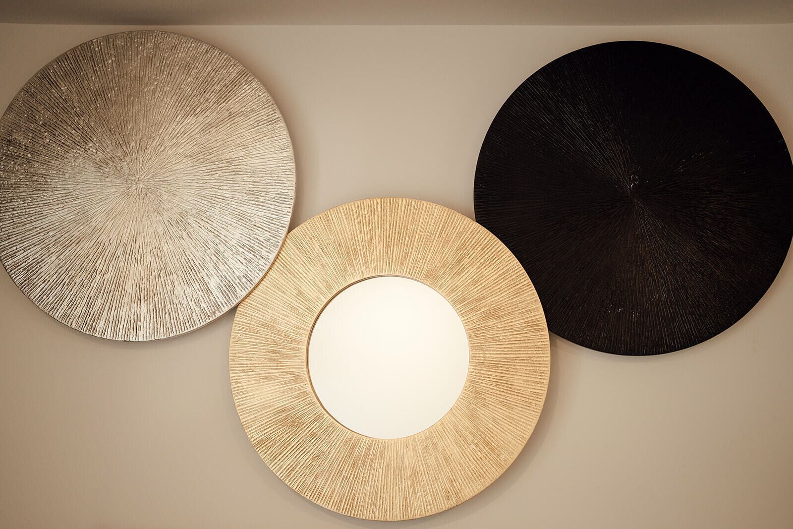 Three circular wall decorations of varying textures and colors.