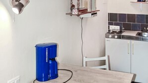 A kitchen with a blue coffee machine, a white chair, and a stove. - Amazing apartment in Lychen (Lychen)