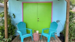 A wooden deck with two turquoise chairs and a small table with a colorful vase. - Retro Style Camper. SW Ocala-Near WEC-Comfy Bed (Ocala)
