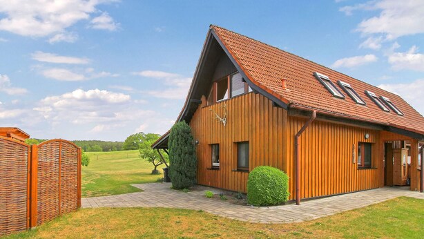 Une maison en bois avec un toit en pente et un petit porche.