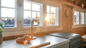 A kitchen with a wooden countertop, a stove, and large windows with a snowy view. - Stunning home in Gol with sauna (Gol)