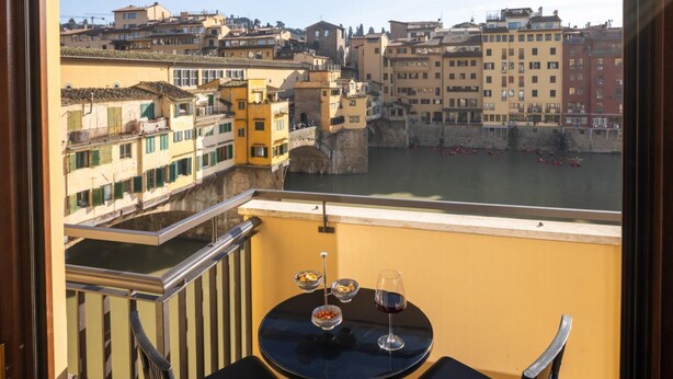 A balcony with a table, two chairs, and a glass of red wine. - Oro1 Florence Luxury Apartment by Mmega (Firenze)