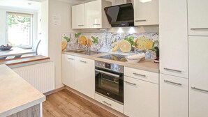 A modern kitchen with white cabinets, a built-in oven, and a microwave. - Doppelhaushälfte Mirow Starsow (Mirow OT Starsow)
