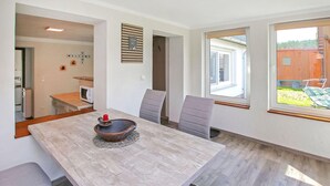 A dining area with a wooden table, grey upholstered chairs, and a unique centerpiece. - Doppelhaushälfte Mirow Starsow (Mirow OT Starsow)