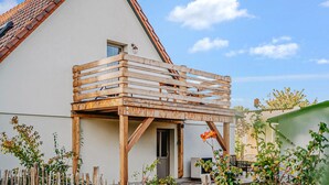 A house with a wooden deck attached to the side, a white exterior, and a tiled roof. - 2 bedroom amazing home in Altwarp (Altwarp)