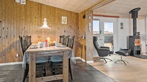 A dining area with a wooden table, chairs, and a hanging light fixture.