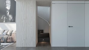 A modern room with a built-in wardrobe, a staircase, and a large abstract painting on the wall.