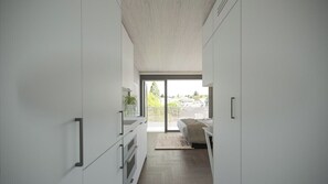 A modern, minimalist bedroom with a large window, a bed, and a view of the outdoors. - Cascada (Portland)