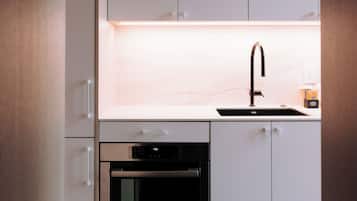 A modern kitchen with white cabinets, a Bosch oven, and a sink.