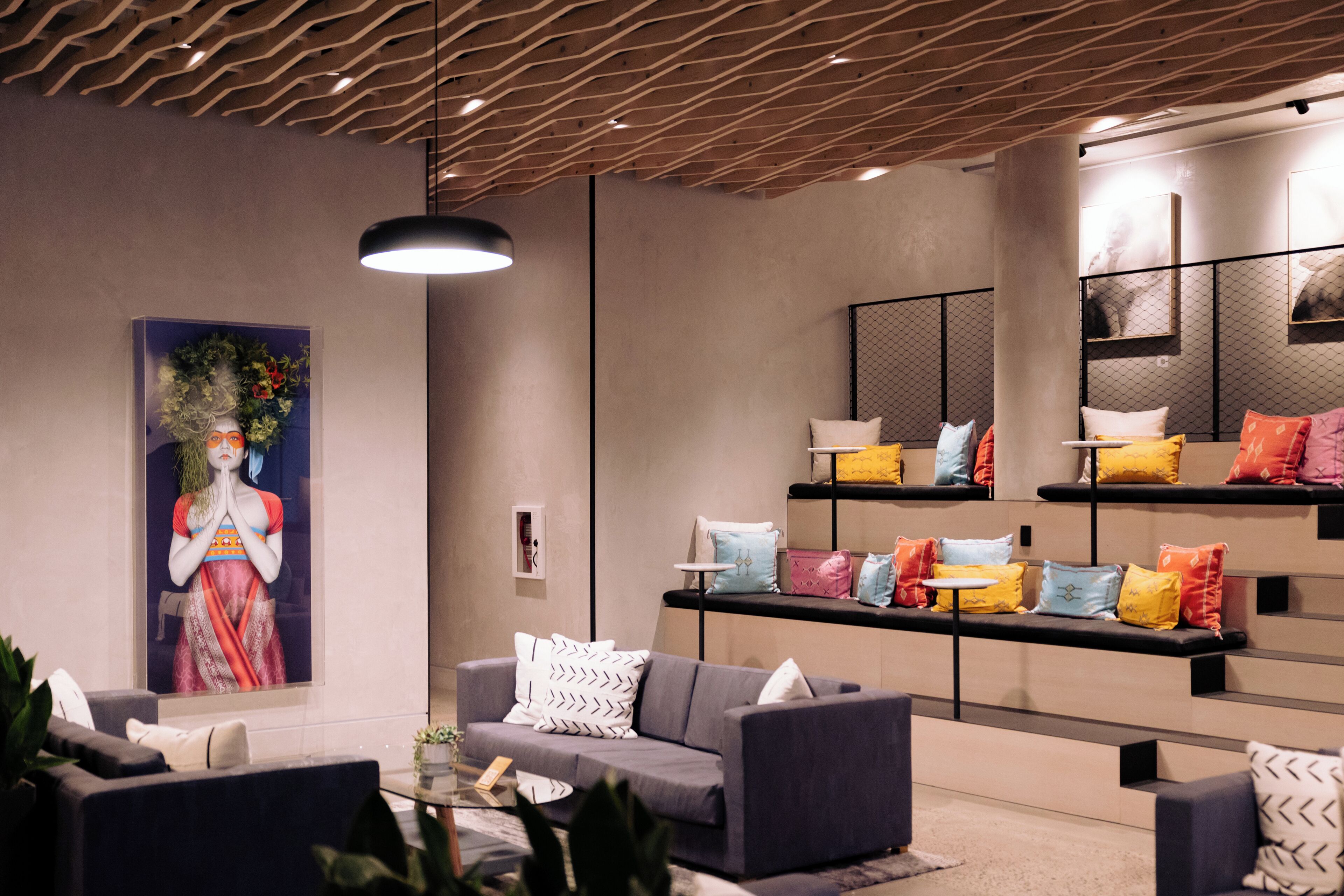A modern living room with a sofa, a coffee table, and a wall-mounted shelf with cushions.