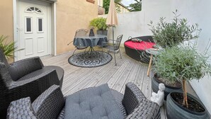 A patio area with wicker furniture, a round table, and potted plants. - Ferienwohnung Rheinsberg (Rheinsberg)