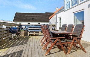 An outdoor deck with a wooden table and chairs, a blue grill, and a sofa. - Lovely home in Thisted with sauna (Thisted)