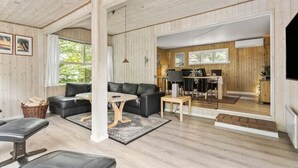 Un salon confortable avec un canapé, une table basse et un coin repas comprenant une table et des chaises.