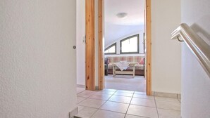 Una escalera conduce a un dormitorio tipo loft con vistas al exterior.