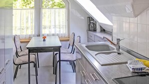 A modern kitchen with a dining table and chairs, a coffee maker, and a sink. - Amazing apartment in Klink with sauna (Klink)