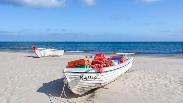 Two boats on a sandy beach with the ocean in the background. - Ferienhaus Trassenheide (Trassenheide (Ostseeba)