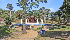 A park with a central amphitheater, surrounded by trees and pathways. - Ferienhaus Trassenheide (Trassenheide (Ostseeba)