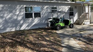 A single-story house with a covered porch and a driveway. - OCEANSIDE BEACH HOUSE-3 BED/2 BATH. GOLF-CART INCLUDED, 100 YARDS FROM BEACH (Myrtle Beach)
