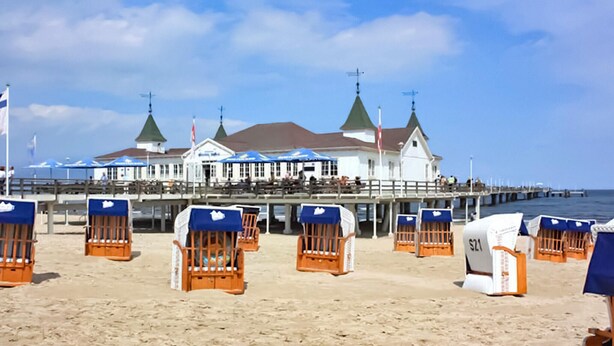 A beachside hotel with multiple rooms, a pier extending into the water, and beach chairs lined up in front. - Nice apartment in Ahlbeck (Seebad) with kitchen (Ahlbeck (Seebad))