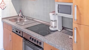 A kitchen with a stove, microwave, sink, and a coffee maker. - Nice apartment in Ahlbeck (Seebad) with kitchen (Ahlbeck (Seebad))