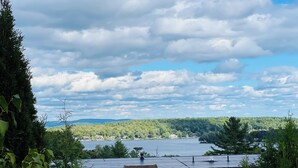 A two-story building with a flat roof, surrounded by greenery and overlooking a body of water. - Lake Winnipesaukee, Weirs Beach! (Laconia)