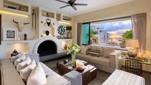 A modern living room with a fireplace, a sofa, a coffee table, and a view of the sea. - Las Villas Puerto Vallarta (Puerto Vallarta)