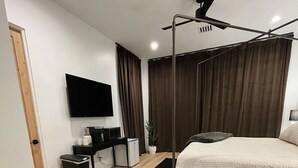 A modern bedroom with a bed, a TV, a ceiling fan, and a black rug. - Luxurious King Suite in Gilbert. Kids are Welcome! (Gilbet)