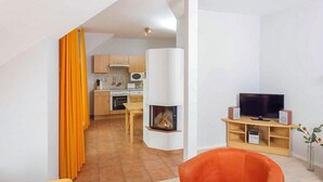 A modern apartment with a kitchen, living room, and a fireplace.