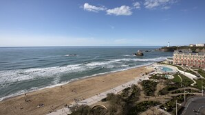 A coastal hotel with a beach view, a swimming pool, and a landscaped garden. - Appartement Victoire, vue mer - Welkeys (Biarritz)