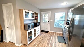 A compact kitchen with a built-in microwave, a refrigerator, and a wooden cabinet with glass doors. - Lake Fork Luxury and Leisure. 2 story cabin in gated resort. Many amenities! (Quitman)