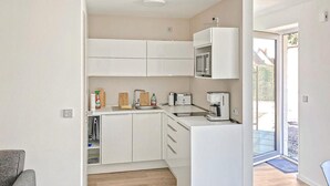 A compact kitchen with white cabinets, a microwave, a coffee maker, and a toaster. - 1 bedroom pet friendly apartment in Poseritz (Poseritz)