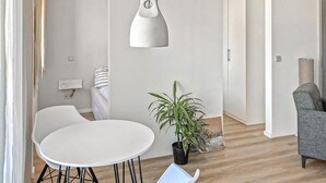 A modern living room with a white round table, a grey sofa, a potted plant, and a pendant light. - 1 bedroom pet friendly apartment in Poseritz (Poseritz)