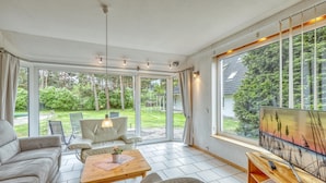 A spacious living room with a large window, a sofa, a coffee table, and a painting. - Ferienwohnung Pruchten (Pruchten)