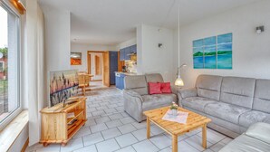 A modern living room with a sofa, a coffee table, and a wooden TV stand. - Ferienwohnung Pruchten (Pruchten)