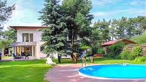 A modern house with a swimming pool, a patio, and a large tree. - Ferienwohnung Pruchten (Pruchten)