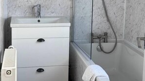 Un bagno con un vanità bianca, uno specchio, una doccia e una vasca da bagno.