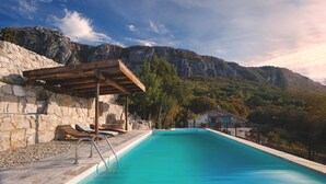 A swimming pool with a wooden pergola, stone walls, and a mountain backdrop. - Gorgeous home in Bribir with private swimming pool, can be inside or outside (Bribir)