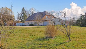 A house with a sloped roof, a garage, and a well-maintained lawn. - Ferienwohnung Zwiedorf (Zwiedorf)